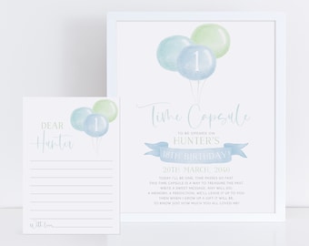 Op de afbeelding: Een aquarel-illustratie van blauwe en groene ballonnen met het nummer 1 op een van de ballonnen. De tekst "Time Capsule" is in cursief geschreven met een blauwe lintbanner eronder die zegt "Te openen op Hunters 18e verjaardag!" De datum "20 maart 2040" staat onder de banner. Een aparte kaart zegt "Lieve Hunter" met regels om te schrijven.
