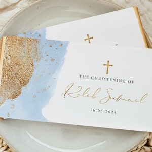 May include: White card with gold foil accents and a blue watercolor background. The card reads "The Christening of Kaleb Samuel 16.03.2024".
