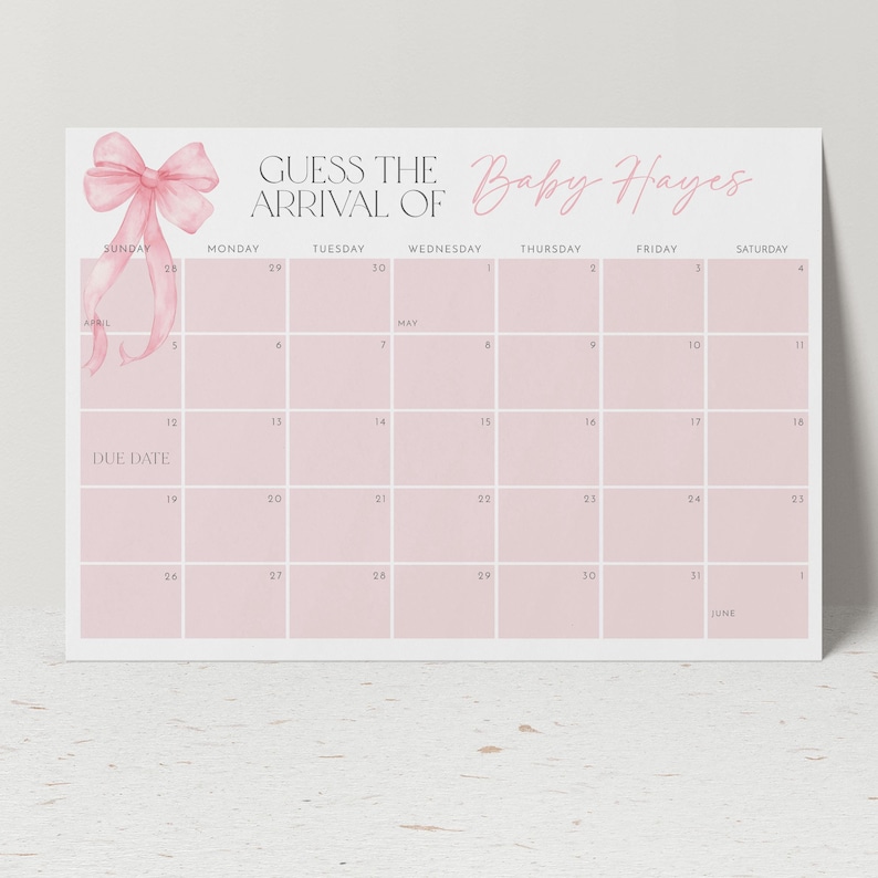 Pode incluir: Um calend&aacute;rio rosa e branco com um la&ccedil;o rosa no topo. O calend&aacute;rio &eacute; para adivinhar a chegada do Baby Hayes. O calend&aacute;rio &eacute; para os meses de abril, maio e junho.