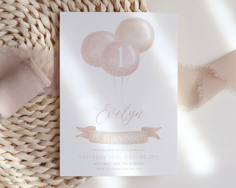 May include: A birthday invitation featuring watercolor balloons in shades of pink and gold. The number "1" is displayed on one balloon. The invitation includes the name "Evelyn" and the text "IS TURNING 1!" in elegant script.