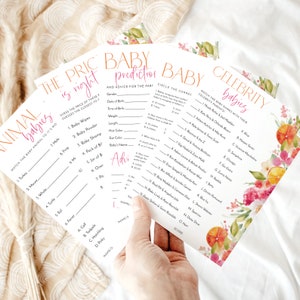 May include: A stack of baby shower game cards with floral and citrus accents. The games include "Animal Babies," "The Price is Right," "Baby Prediction," and "Celebrity Babies." The cards are held by a hand.