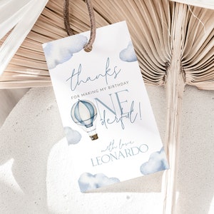 May include: A white thank you tag with blue watercolor clouds and a hot air balloon. The text reads "Thanks for making my birthday one derful! with love Leonardo".