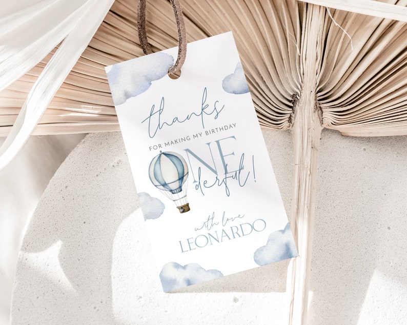May include: A white thank you tag with blue watercolor clouds and a hot air balloon. The text reads "Thanks for making my birthday one derful! with love Leonardo".