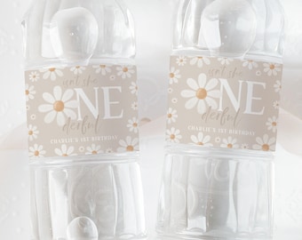 May include: Two clear plastic water bottles with beige labels featuring white daisies and the text "Isn't she one derful" and "Charlie's 1st Birthday".