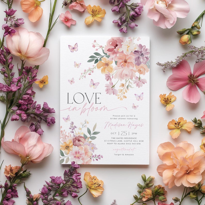Op de afbeelding: Een bloemige bruidsdoucheinvitatie met vlinders en de tekst "LOVE in bloom" en "Madison Hayes". De uitnodiging is versierd met aquarelbloemen in roze, gele en paarse tinten.