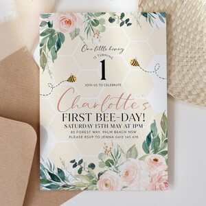 May include: A light beige invitation with floral and bee illustrations. The text reads "Our little honey is turning 1" and "Charlotte's First Bee-Day!" with event details. The design includes watercolor roses and greenery.
