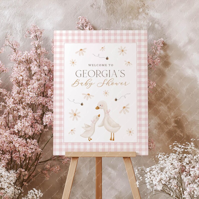 May include: Pink and white gingham baby shower sign with the text "Welcome to Georgia's Baby Shower" and a watercolour illustration of two ducks with flowers and bees.
