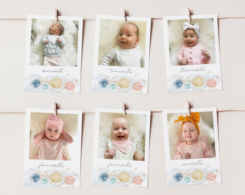 Op de afbeelding: Zes foto's van een baby in een roze en witte outfit, elke foto is gelabeld met een maand van de leeftijd van de baby. De foto's zijn in een rij gerangschikt en hangen aan een muur met wasknijpers. De foto's zijn versierd met een aquarel achtergrond van planeten en sterren.