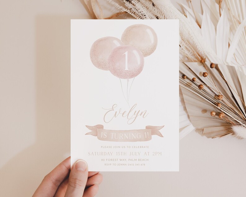 May include: A birthday invitation with three pink balloons, the number 1, and the name "Evelyn". The invitation includes the text "Evelyn is turning 1!" and event details. The design features a soft, watercolor style with a banner.