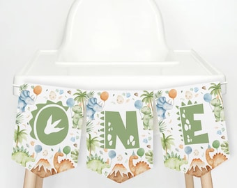 Könnte beinhalten: Ein grünes und weißes Dinosaurier-Banner mit dem Wort "ONE" in grünen Buchstaben. Das Banner ist mit Dinosauriern, Palmen und Fußabdrücken verziert. Es ist perfekt für eine erste Geburtstagsfeier.