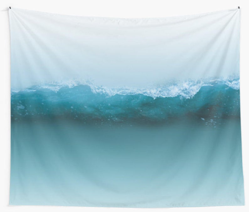 May include: A wall tapestry featuring a serene ocean wave design. The image showcases a gradient of colors, transitioning from a light blue at the top to a deeper teal at the bottom. The wave crests with white foam, creating a dynamic and calming visual.