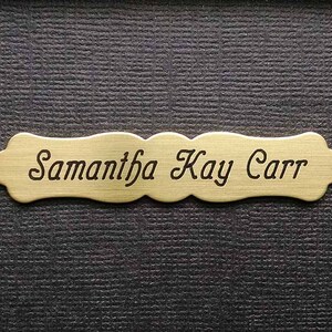 May include: A gold-colored metal nameplate with the engraved text "Samantha Kay Carr".