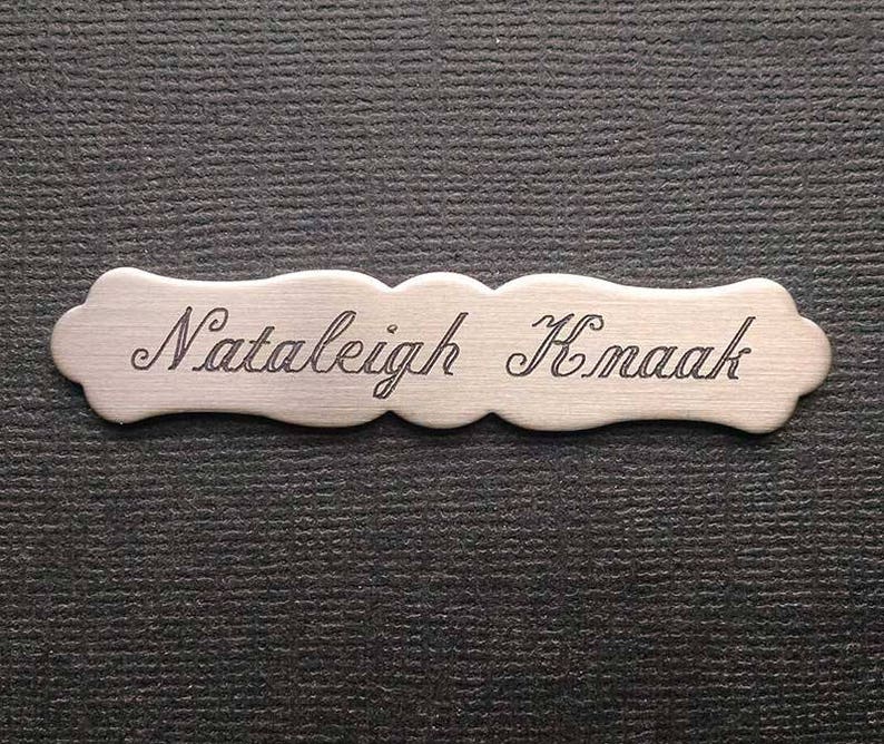 May include: A silver nameplate with the engraved text "Nataleigh Kmaak".