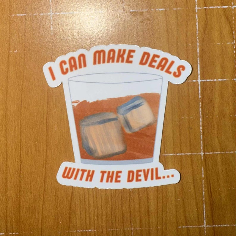 K&ouml;nnte beinhalten: Ein Aufkleber mit einem Cocktail mit Eisw&uuml;rfeln. Der Text "I CAN MAKE DEALS WITH THE DEVIL..." ist in Orange auf wei&szlig;em Hintergrund gedruckt.
