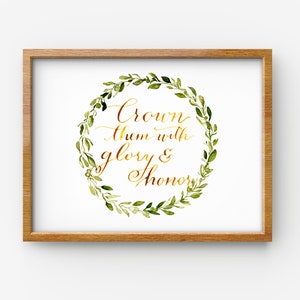 May include: A framed print featuring a watercolour wreath of green leaves and the text "Crown them with glory & honour" in gold lettering.