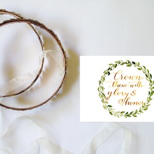 May include: A white card with a gold calligraphy quote "Crown them with glory & honour" surrounded by a green watercolour wreath.