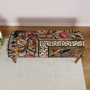 Puede incluir: Banco rectangular con un estampado floral y de p&aacute;jaros. El banco tiene un fondo verde claro con rosas rojas, flores amarillas y un dise&ntilde;o de p&aacute;jaro. Las patas son de madera.