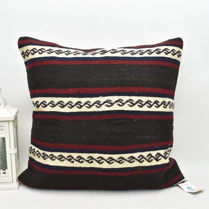 May include: Square decorative pillow with a striped pattern in black, cream, and burgundy. The pillow features a geometric design and is suitable for home decor. The pillow is approximately 18 inches square.
