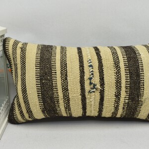 May include: A black and white striped throw pillow with a woven texture. The pillow is made of a natural fiber and has a rustic look.