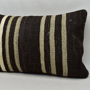 May include: A brown and white striped throw pillow with a woven texture.