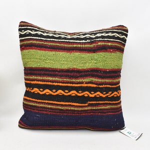 May include: A colorful striped throw pillow with a woven design in shades of green, orange, red, black, and blue. The pillow is made of a soft, textured fabric.