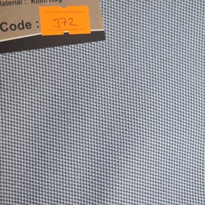 Puede incluir: Primer plano de una tela a cuadros azul y blanco. Una etiqueta con el texto "Código: 372" está adherida a la tela. El material parece ser una alfombra Kilim.