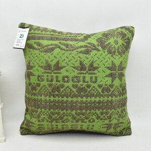 May include: Green and brown patterned throw pillow with the text "GULOGLU" in the center.