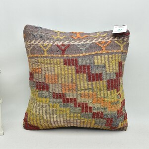May include: A colorful, geometric patterned throw pillow with a gray background. The pillow is made of woven fabric and has a variety of colors, including red, orange, yellow, and blue.