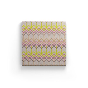 May include: Square canvas art with a geometric pattern. The design features interlocking diamond shapes in shades of pink, yellow, brown, and gray on a neutral background. The artwork is displayed against a white backdrop.