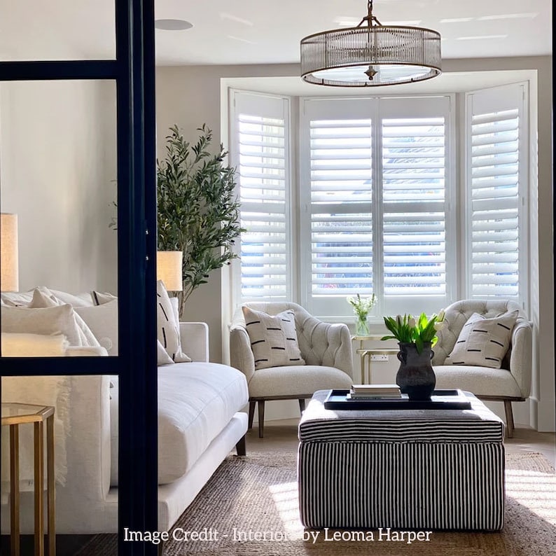 Lifestyle image of a living room, featuring Martelo and Mo's black footstool tray