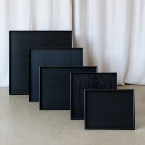 Image of 5 ottoman tray options, rectangular and square trays in black.