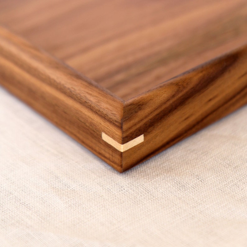 Contrasting maple wood corner pin detail on a walnut ottoman tray