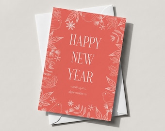 Może przedstawiać: Koralowa kartka okolicznościowa z białym napisem HAPPY NEW YEAR oraz shyne creative co. Kartka posiada białą obwódkę z rysunkami płatków śniegu, liści i ptaków i leży na gładkiej, białej kopercie.