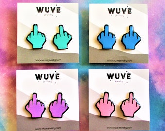 Puede incluir: Cuatro pares de pendientes en varios colores: turquesa, azul, morado y rosa. Cada pendiente tiene la forma de una mano haciendo una peineta, con un contorno negro. Los pendientes se exhiben en tarjetas blancas con el logotipo "WUVE jewelry".
