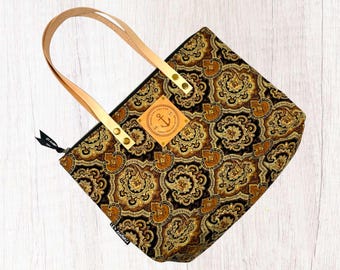 Bolso tote acolchado con estampado paisley, asas de cuero y diseño con versículo bíblico.