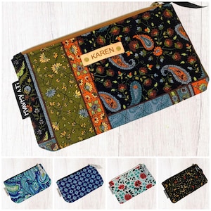May include: A set of six colourful zippered pouches with paisley and floral patterns. The pouches are made of fabric and have a personalised name tag with the name "KAREN" on one of the pouches.