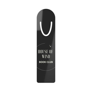 Op de afbeelding: Zwarte bladwijzer met een wit bladwijzerlint. De bladwijzer heeft een witte cirkel met de tekst "HOUSE OF WIND BOOK CLUB" in een wit sans-serif lettertype.