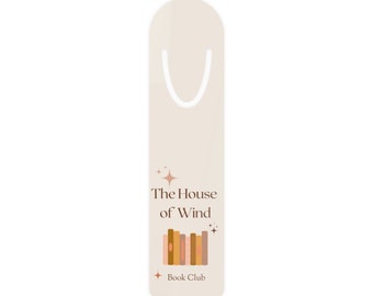 May include: A beige bookmark with a white ribbon loop. The bookmark features a stack of books with a brown, orange, and pink color scheme. The text "The House of Wind" is printed in brown text. Below the books, the text "Book Club" is printed in brown text.