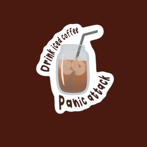 Pode incluir: Um adesivo branco com uma ilustração de desenho animado de um frasco de vidro cheio de café gelado e um canudo. O texto "Drink iced coffee Panic attack" está escrito em torno do frasco.