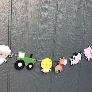 May include: A farm-themed banner with a green tractor, a yellow chick, a brown horse with a red bandana, a black and white cow, a pink pig, and a white sheep.