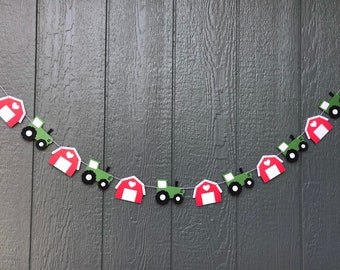 May include: A red and green farm-themed banner with alternating red barns and green tractors. Each barn has a white heart on the front. The banner is strung on a white string.