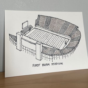May include: A black and white line drawing of a stadium, with the text "FIRST BANK STADIUM" below the image.