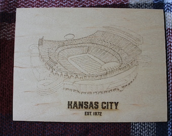 May include: A wood-burned image of Arrowhead Stadium, home of the Kansas City Chiefs, with the text "KANSAS CITY EST. 1972".