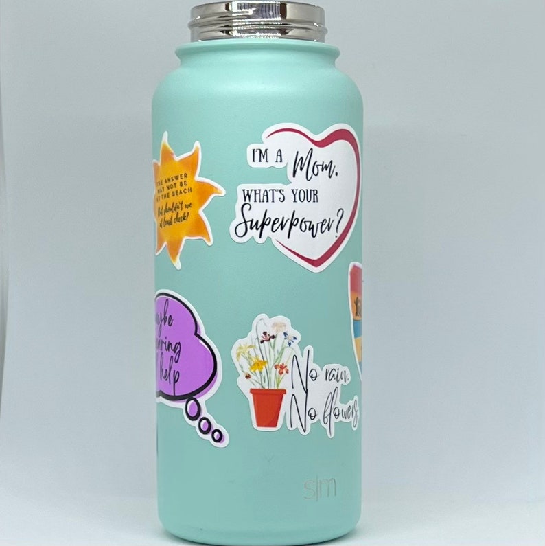 May include: A turquoise water bottle with various stickers, including a heart-shaped sticker that says "I'm a Mom. What's your superpower?" and a sticker with a flower pot and the text "No rain, No flowers".