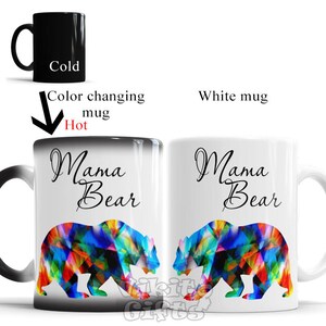 May include: A color-changing mug with a black exterior and a white interior. The mug features a colorful geometric bear design and the text "Mama Bear". The mug changes color when hot liquid is added.