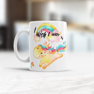 May include: White ceramic mug with a rainbow and a unicorn illustration. The text "I wish I was a" is printed on the mug.
