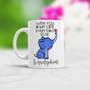 Könnte beinhalten: Weiße Keramiktasse mit einer blauen Elefantenillustration und dem Text "With you in my life everything else is irrelephant".