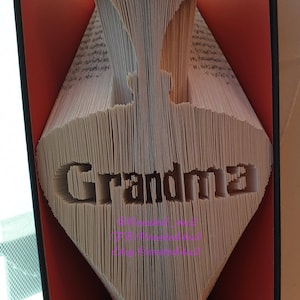Może przedstawiać: Książka złożona w kształt diamentu z wyciętym słowem "Grandma" na stronach. Książka jest otwarta, a strony są złożone, aby stworzyć efekt 3D.