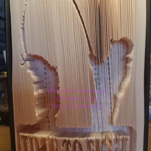 May include: A book with pages folded into a 3D sculpture of a heart with the word "FOREVER" at the bottom.
