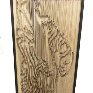 May include: A book art sculpture of a wolf, created by folding the pages of a book. The sculpture is made from a book with a brown cover.